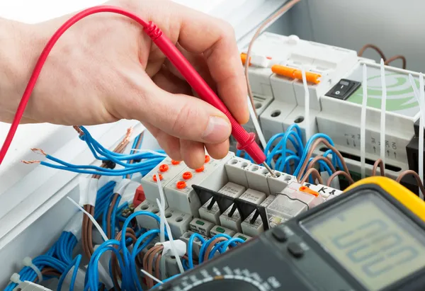 Electrician probing electrical panel