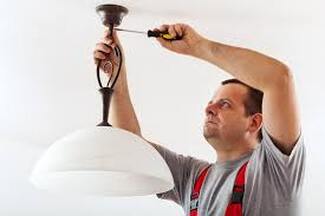 Electrician installing ceiling light